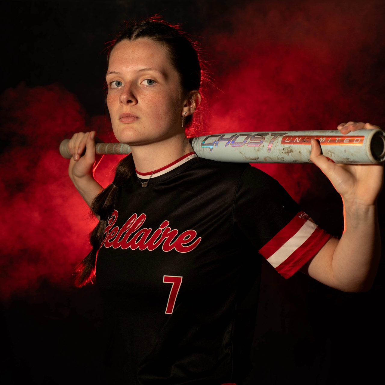Abi Yuhaus posing with bat against red smoke background